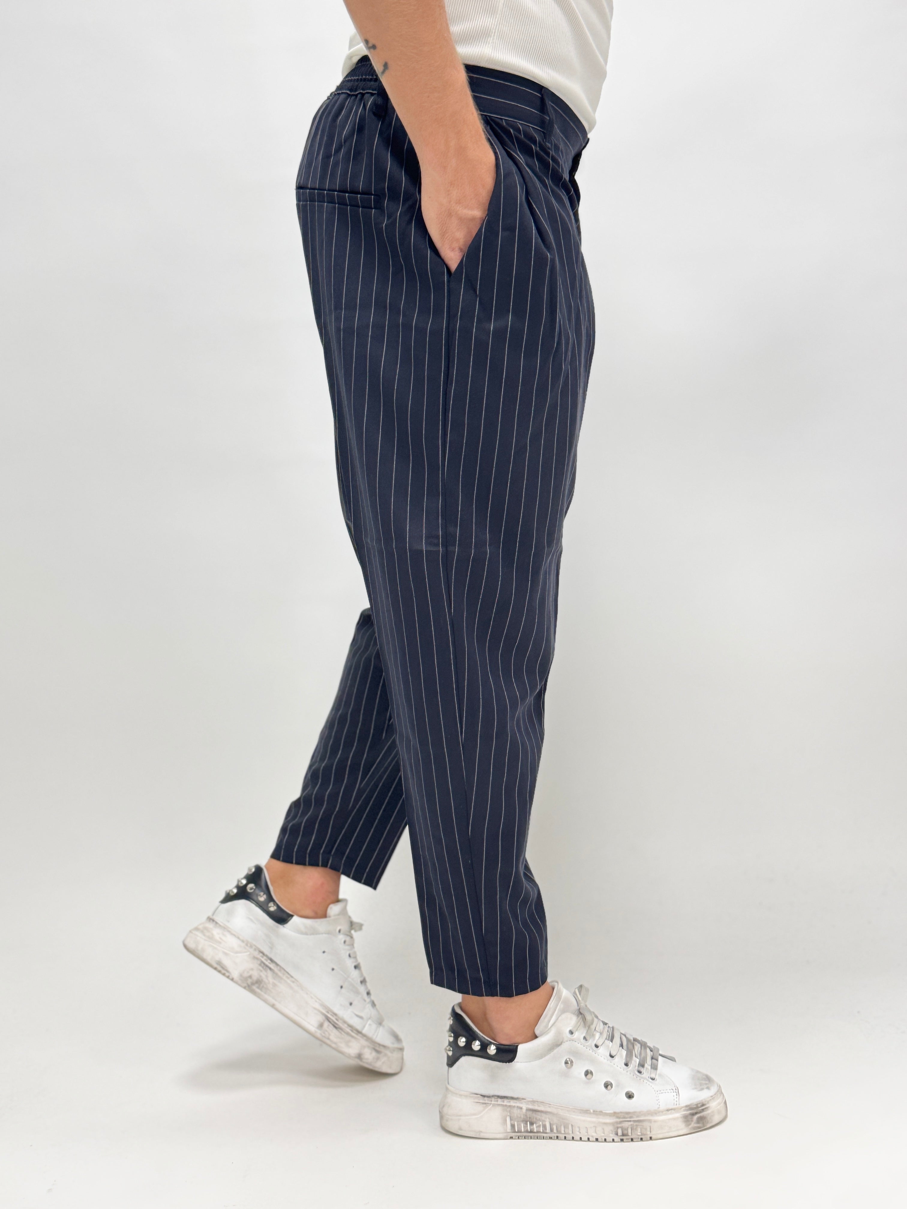 Pantalón MADRID de AUTUNNO/INVERNO 26, con pinzas y rayas azules, vista frontal en un entorno casual.