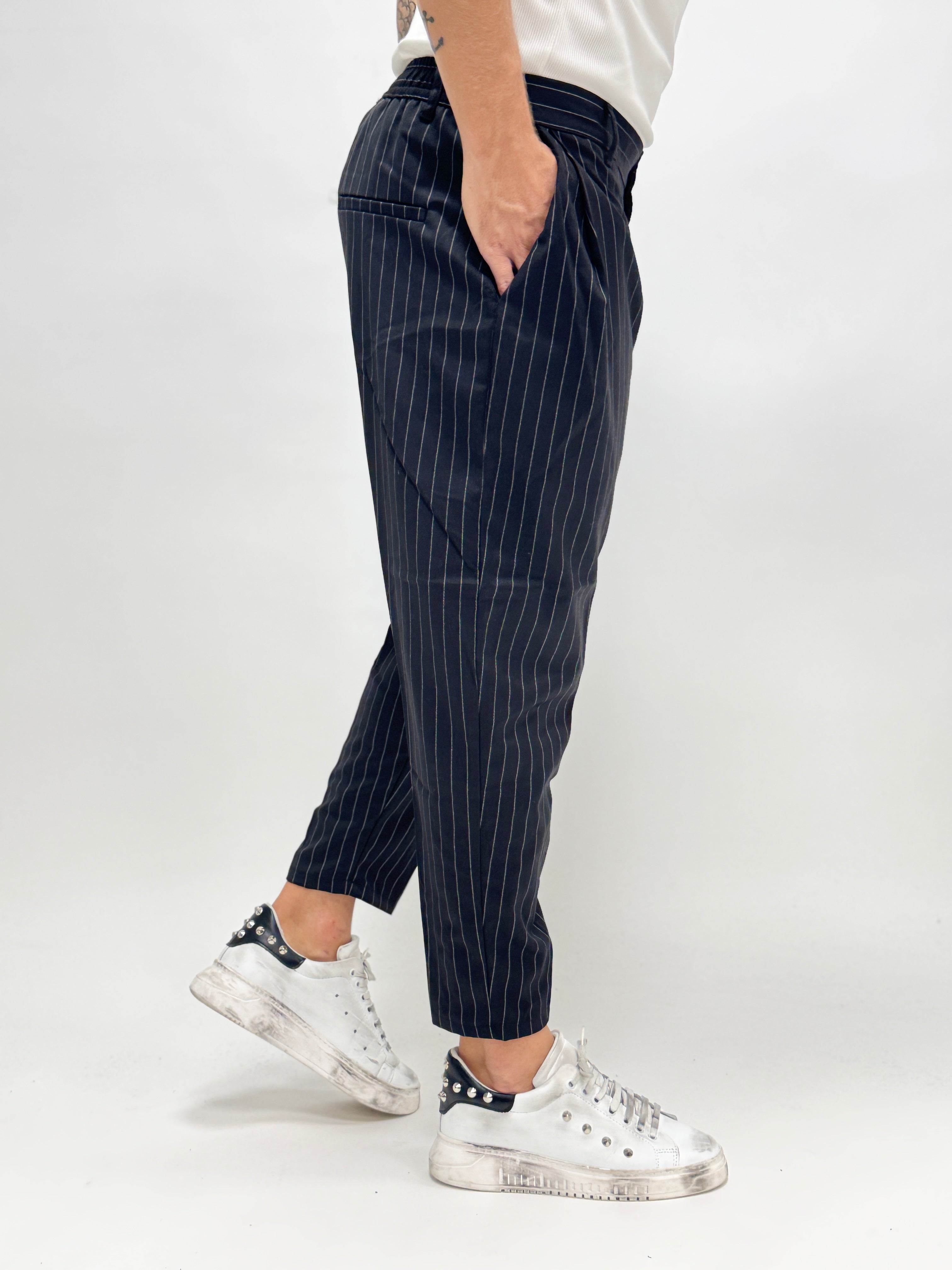 Pantalón MADRID de AUTUNNO/INVERNO 26 en rayas negras con pinzas, vista frontal sobre fondo neutro.