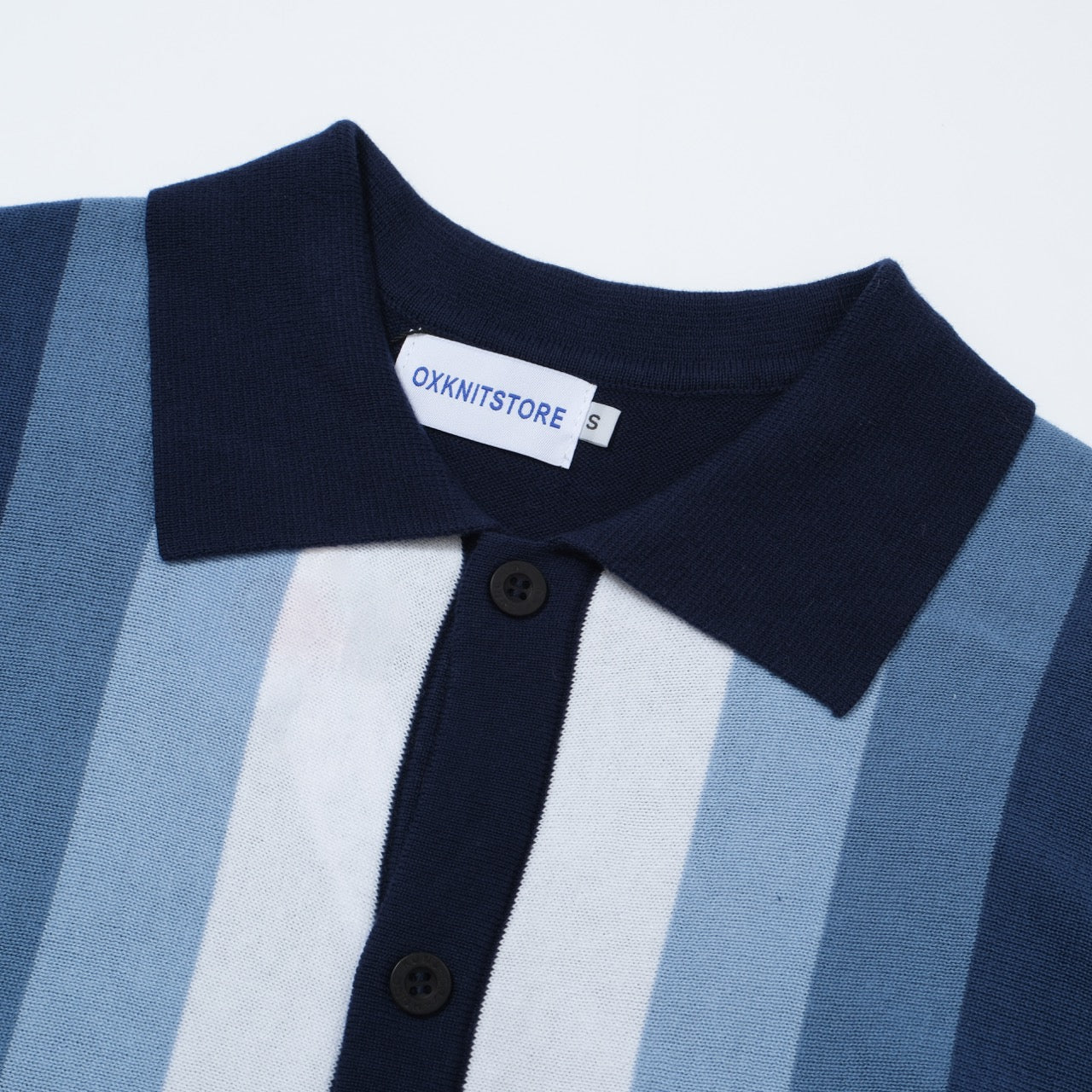 Men's OXKNIT 60s vertical stripe knit polo shirt in navy and sky blue, featuring a classic button-up design.