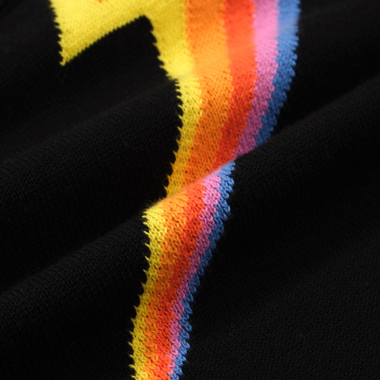 Women's black sweater featuring a retro 60s MOD style lightning bolt design by OXKNIT, with long sleeves and knit texture.