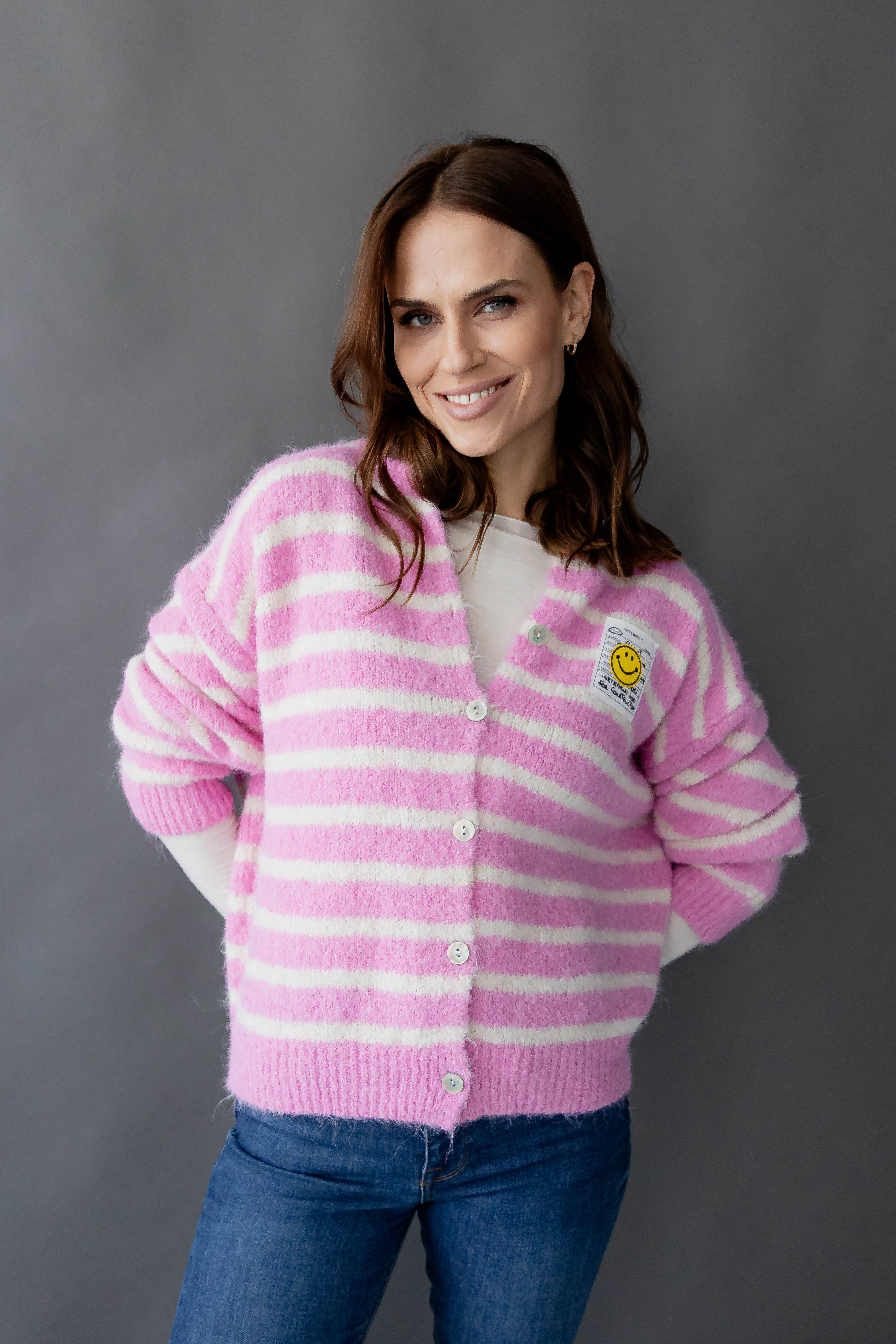 Gestreifter Cardigan "Smiley" by von Herzen featuring a playful smiley design in vibrant colors, displayed on a mannequin.