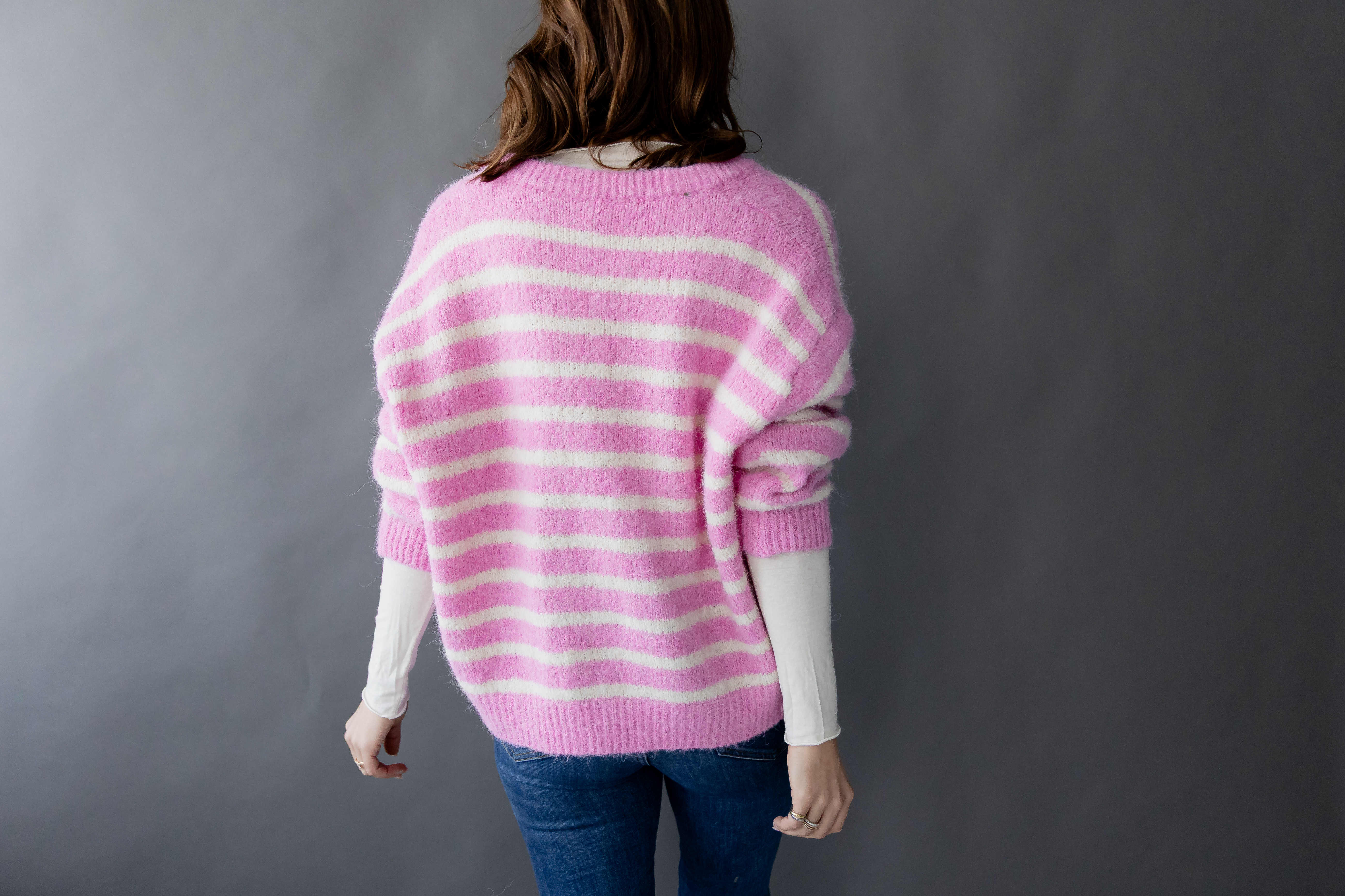 Gestreifter Cardigan "Smiley" von Herzen displayed on a mannequin, featuring a cheerful smiley design and soft fabric.