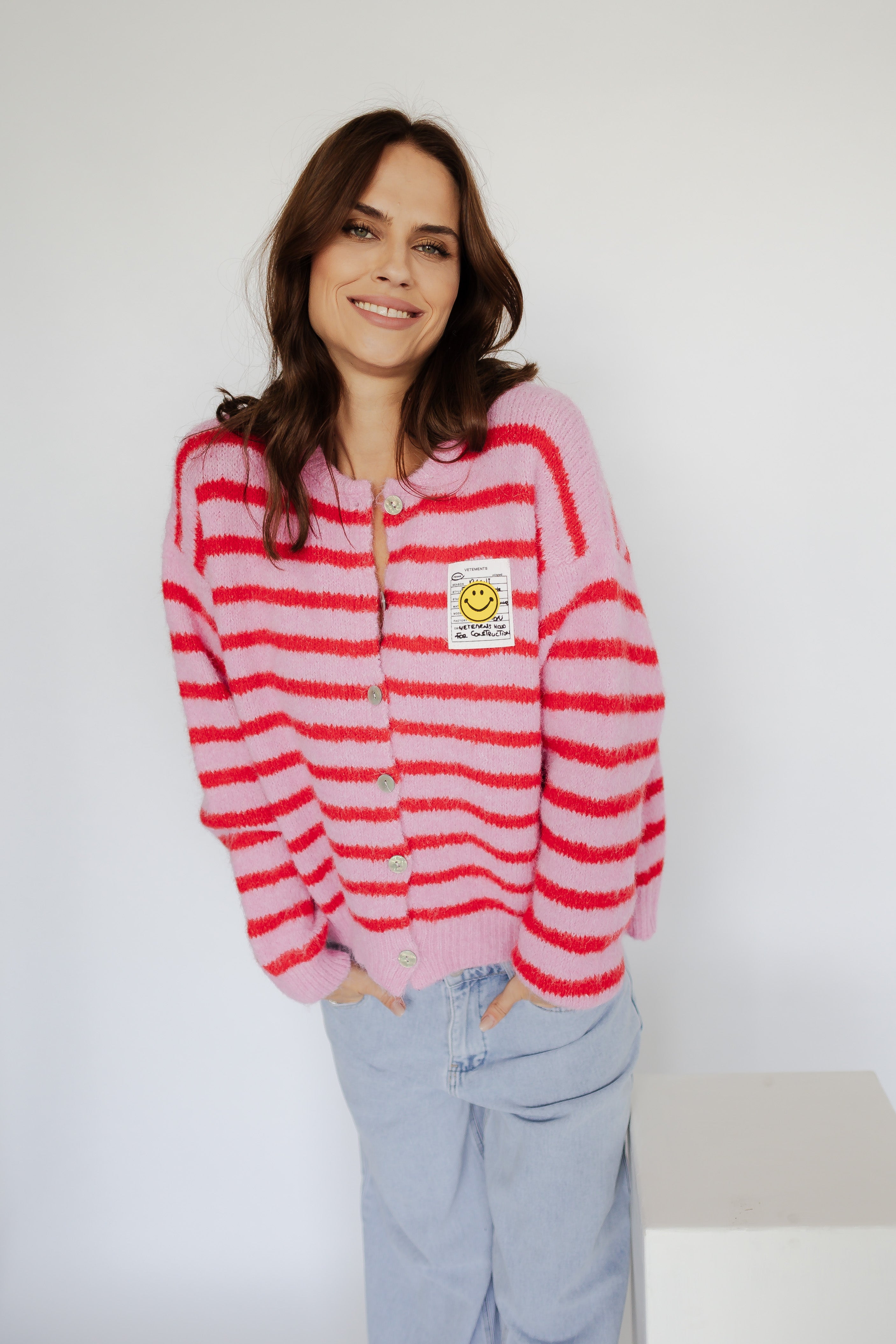 Striped cardigan with smiley face design by von Herzen, showcasing vibrant colors and a cozy fit.